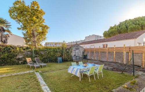 a backyard with a table and chairs and a fence at Stunning Home In Royan With Wifi in Royan
