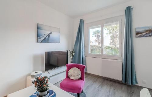 - un salon avec une chaise rose et une télévision dans l'établissement Stunning Home In Royan With Wifi, à Royan