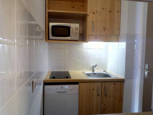 une petite cuisine avec un évier et un micro-ondes dans l'établissement Charmant Appartement Méribel Mottaret, 5 Pers, Accès Piste, Proche Commerces - FR-1-355-178, à Méribel