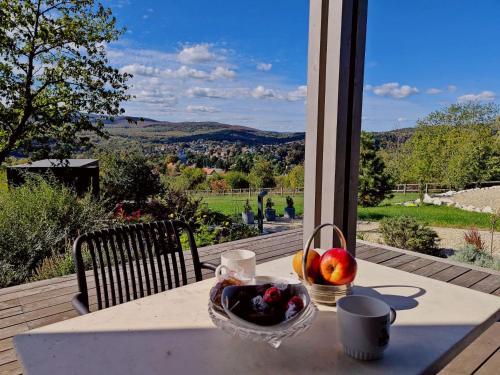 a basket of fruit sitting on a table with a view at Casa Slarku - Luxury Container Houses in Miskolc