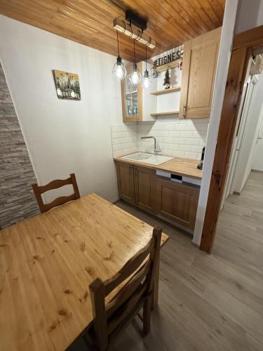 - une cuisine avec une table en bois et un évier dans l'établissement Appartement Tignes 2100 - 6-8 personnes - 2 chambres - 3 Télévisions - Netflix & Wifi inclus, à Tignes