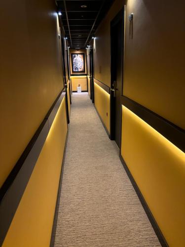 a corridor of a hallway with yellow walls and a long aisle at DAOS Suites & Terrace Marbella in Marbella