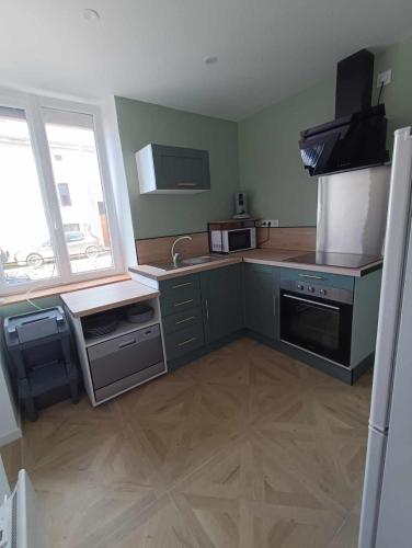 une cuisine avec un évier et une cuisinière four supérieur dans l'établissement Appartement cosy à Chamagne, à Chamagne