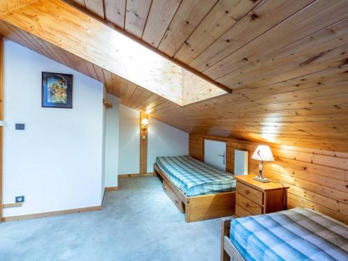 deux lits dans une chambre avec plafonds en bois dans l'établissement Appartement à Méribel Mottaret avec départ skis aux pieds, balcon et mezzanine - FR-1-355-19, à Méribel