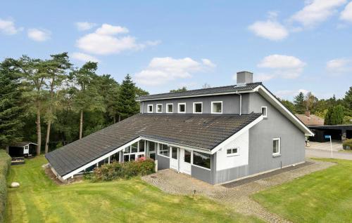 a house with a gray roof and a yard at Stunning Home In Roslev With Sauna in Glyngøre