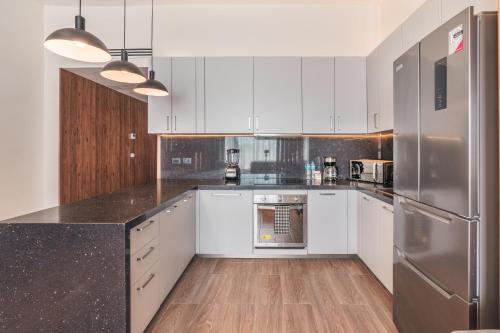 a kitchen with white cabinets and stainless steel appliances at Probar Suites Punta Cana in Punta Cana