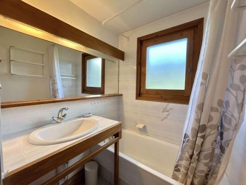 La salle de bains est pourvue d'un lavabo, d'une fenêtre et d'une baignoire. dans l'établissement Appartement 4 pièces + cabine - 8 couchages avec jardin et terrasse - Megève - FR-1-597-22, à Megève