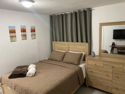 a bedroom with a bed with a dresser and a mirror at Private and Comfortable Suite near Airport Miami in Miami
