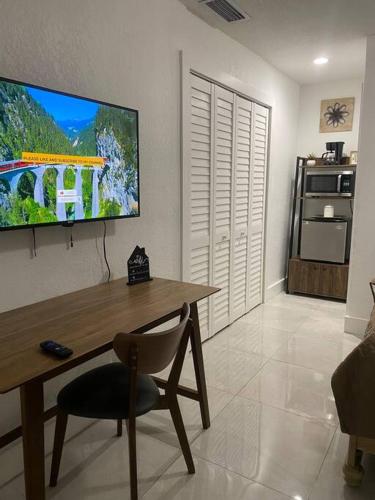 a living room with a table and a television on the wall at Private and Comfortable Suite near Airport Miami in Miami