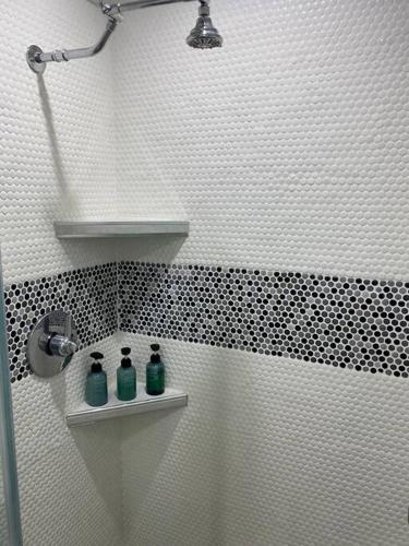 a bathroom with two green bottles on a shelf at Private and Comfortable Suite near Airport Miami in Miami