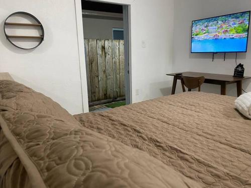 a bedroom with a bed and a table and a television at Private and Comfortable Suite near Airport Miami in Miami