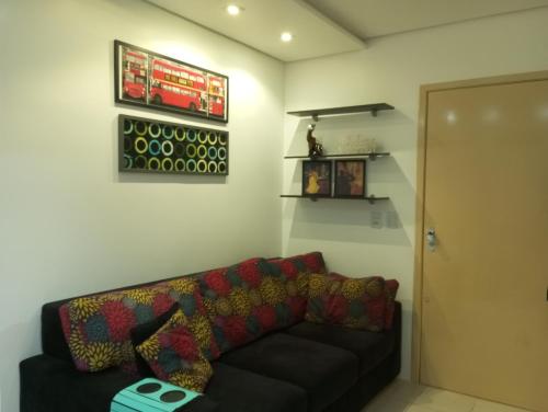 a living room with a black couch and a door at Apartamento perto da Orla em frente ao Beira Rio in Porto Alegre