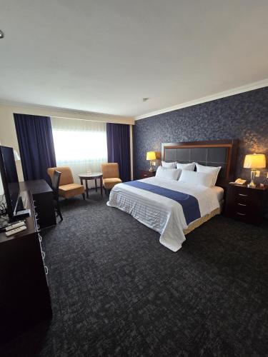 a hotel room with a large bed and a table at Hotel Two Select in Culiacán