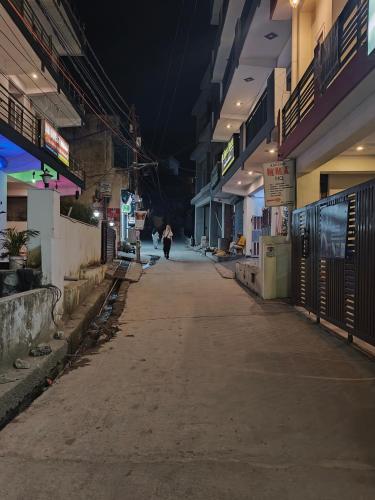 a person walking down an empty street at night at Mild Life Hostel Rishikesh in Rishīkesh