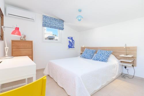 une chambre blanche avec un lit et un bureau dans l'établissement Les VOILES DE GOLFE, au Golfe-Juan