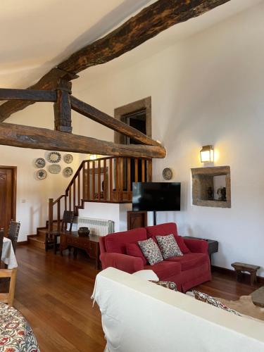 a living room with a red couch and a staircase at Casal da Gata in Guarda