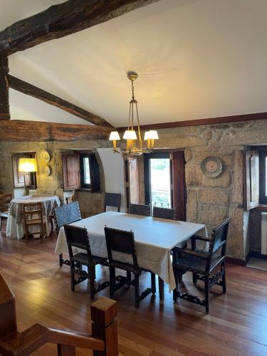 a dining room with a white table and chairs at Casal da Gata in Guarda