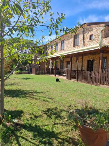 a dog sitting in the yard of a house at Agriturismo e Glamping Serraiola Alta in Frassine