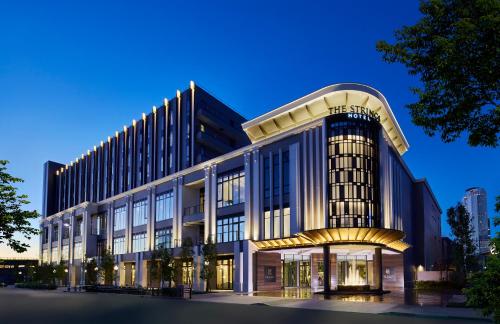 un gran edificio de oficinas con una fachada iluminada en The Strings Hotel Nagoya, en Nagoya