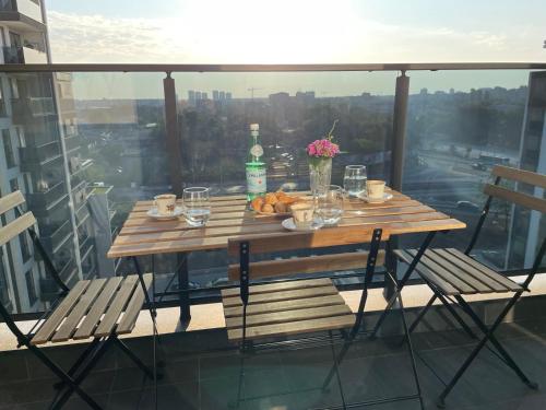 a table with a plate of food on a balcony at Platinum Luxury Industrial 3 Room Unit City-Center in Plovdiv