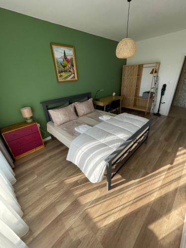 a bedroom with a large bed in a green wall at Platinum Luxury Industrial 3 Room Unit City-Center in Plovdiv