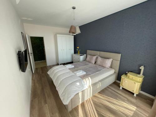 a bedroom with a large bed and a blue wall at Platinum Luxury Industrial 3 Room Unit City-Center in Plovdiv