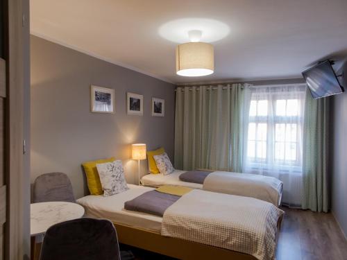 a hotel room with two beds and a television at Baszta Grodzka in Jelenia Góra
