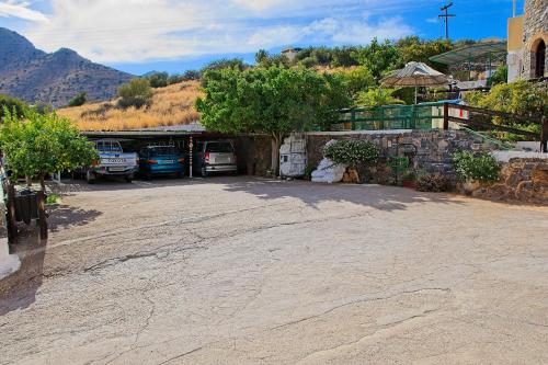 a parking lot with cars parked in front of a building at Milos Apartments in Elounda