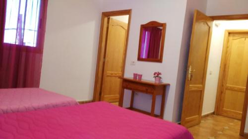 a bedroom with two beds and a mirror at Pensión Amparo Las Hayas in Valle Gran Rey