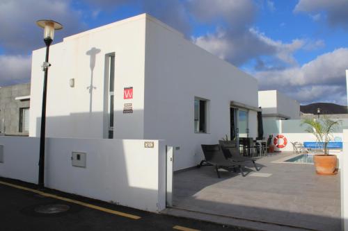 un bâtiment blanc avec un lampadaire à côté dans l'établissement Villa Marina Rubicón DeLuxe, à Playa Blanca