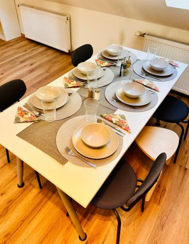 a white table with plates and dishes on it at Apartment Mirador an der Hohen Wand in NÖ in Grünbach am Schneeberg