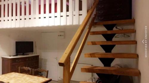 Cette chambre dispose d'un escalier en bois et d'une télévision. dans l'établissement Jean pierre, à Valence