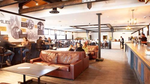 a restaurant with leather furniture and people sitting at tables at Invermere Inn & Suites in Invermere