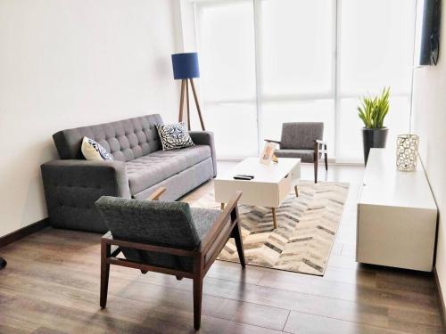 a living room with a couch and a chair at Two Beautiful 1 BR apts, 2 floors apart HS WiFi! in Mexico City