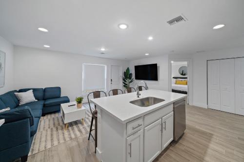 a kitchen and living room with a blue couch at New Construction Home 10 to Beach 5 to Downtown in West Palm Beach