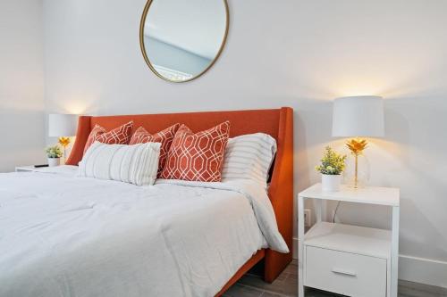 a bedroom with an orange bed with a mirror at New! Few minutes to Downtown, 10 to the Beach! in West Palm Beach
