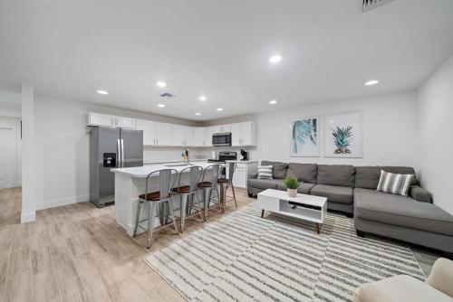 a living room with a couch and a kitchen at New! Few minutes to Downtown, 10 to the Beach! in West Palm Beach