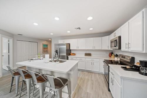 a kitchen with white cabinets and a large white island at New! Few minutes to Downtown, 10 to the Beach! in West Palm Beach
