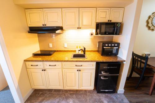 a kitchen with white cabinets and a sink and a microwave at Super 8 by Wyndham Amherst NS in Amherst