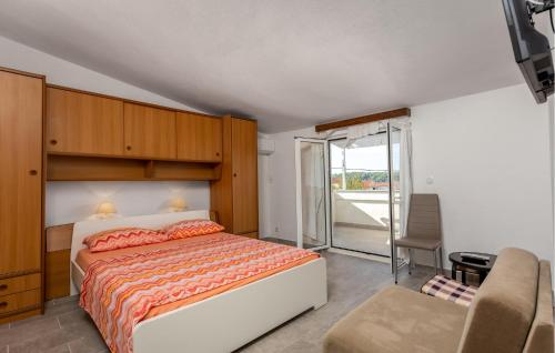 a bedroom with a bed and a sliding glass door at Lovely Apartment In Barbat With Wifi in Barbat na Rabu