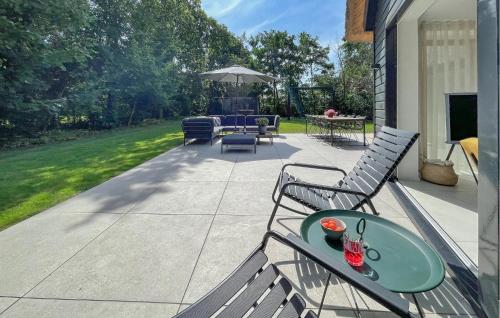 a patio with chairs and a table and an umbrella at Pet Friendly Home In Ballum With Sauna in Ballum