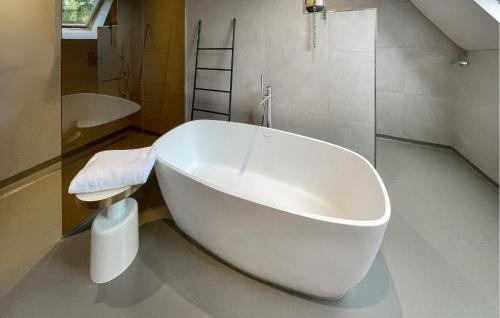 a white bath tub in a bathroom with a shower at Pet Friendly Home In Ballum With Sauna in Ballum