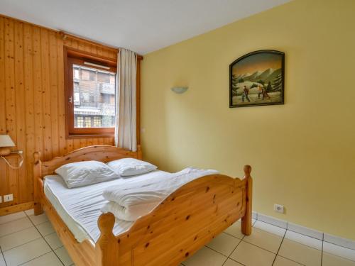 une chambre avec un lit en bois et une fenêtre dans l'établissement Appartement Centre Morzine, Proche Pistes, Balcon, Parking, 6 Pers. - FR-1-684-7, à Morzine