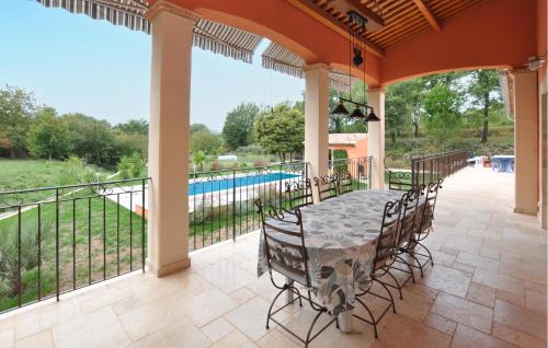 un patio extérieur avec une table et des chaises ainsi qu'une piscine dans l'établissement Awesome Home In Villecroze With Wifi, à Villecroze