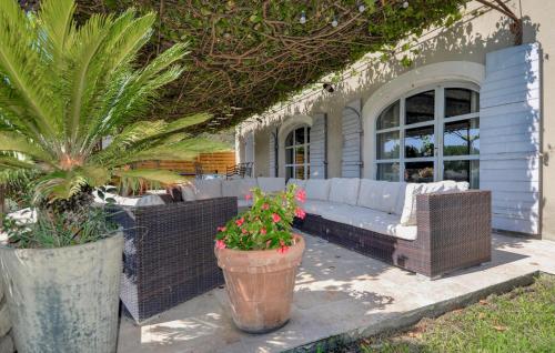 une terrasse avec des meubles en osier et des plantes dans l'établissement 4 Bedroom Awesome Home In Noves, à Noves