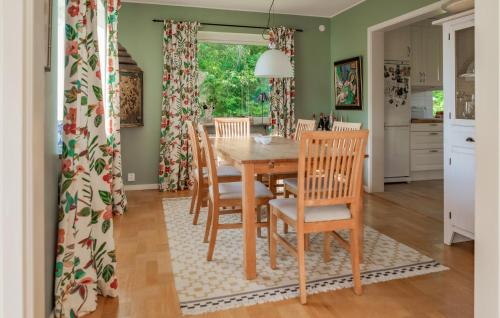a kitchen and dining room with a wooden table and chairs at Lovely Home In Båstad With Sauna in Båstad