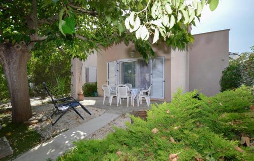 un patio avec une table et des chaises devant une maison dans l'établissement Beautiful Home In Cervione With Wifi, à Cervione