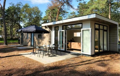 a small house with a table and chairs and an umbrella at 2 Bedroom Awesome Home In Hellendoorn in Hellendoorn