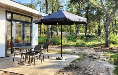 a table and chairs with an umbrella on a patio at 2 Bedroom Nice Home In Hellendoorn in Hellendoorn