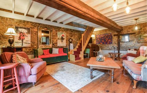Il comprend un salon doté d'un mobilier rouge et d'un mur en briques. dans l'établissement Lovely Home In Les Loges-Marchis, à Les Loges-Marchis